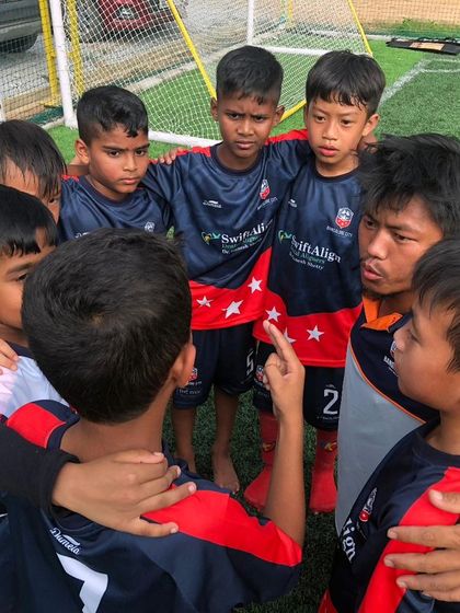 Huddled together, our young team shows their unity and focus before a match. We teach the importance of teamwork from day one.