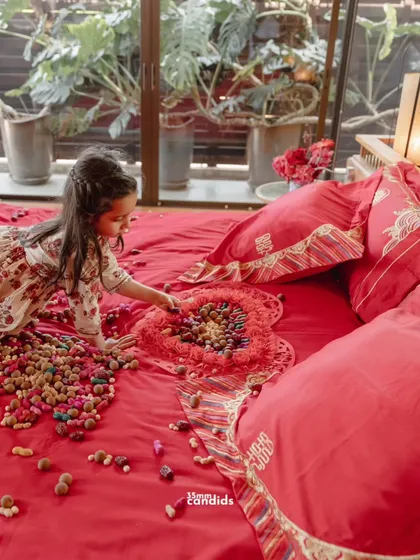 A young girl plays on the wedding bed, decorated with nuts and dates. This tradition symbolizes a sweet and long-lasting marriage and the hope for future children.