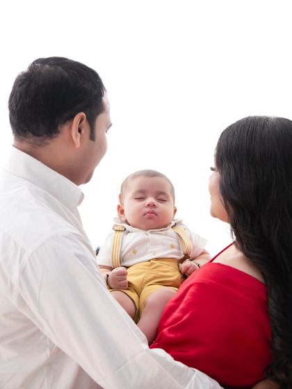 A quiet moment of adoration. The parents' loving gaze on their sleeping baby tells a story of profound love and peace.