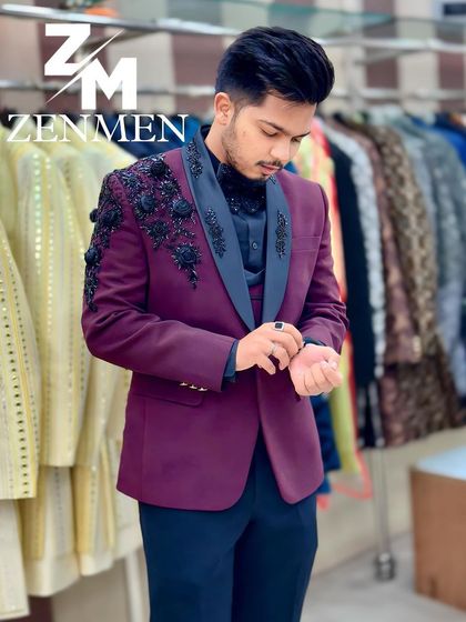 Adjusting the cuff on the wine-colored tuxedo. This shot highlights the detailed floral work and the perfect fit of the sleeve.