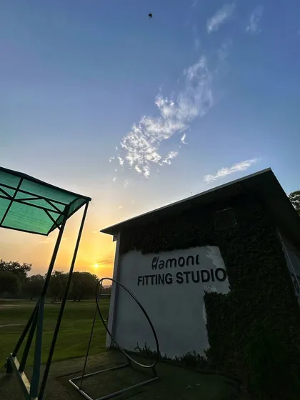 A beautiful sunset view of our Fitting Studio, with the putting green and a practice hoop in the foreground.