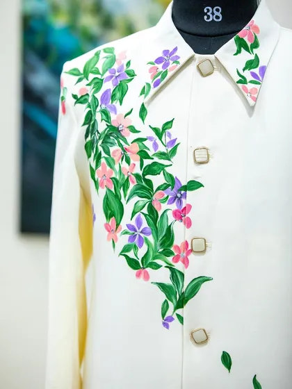 The finished floral Lachka suit on a mannequin. The flowers gracefully climb up the jacket, drawing the eye and adding a touch of natural beauty.