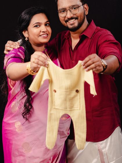 "We can't wait to meet you." This couple holds up a tiny baby onesie, a simple and adorable prop that perfectly captures their excitement and preparation for their new arrival.