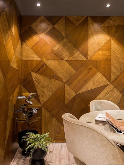 The discussion room is enveloped in a geometric veneer pattern, creating a warm, intimate, and visually stunning environment for client meetings.