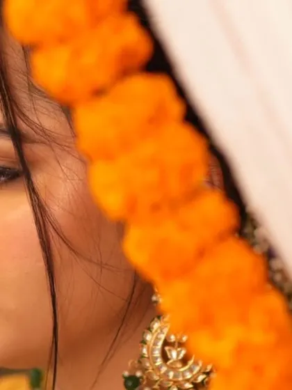 A delicate and artistic profile shot, highlighting the soft shimmer on the eyes and the traditional nath.