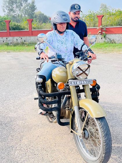 Guiding a student as she practices maneuvering the bike. My constant presence ensures safety and provides immediate feedback to correct and improve her technique.