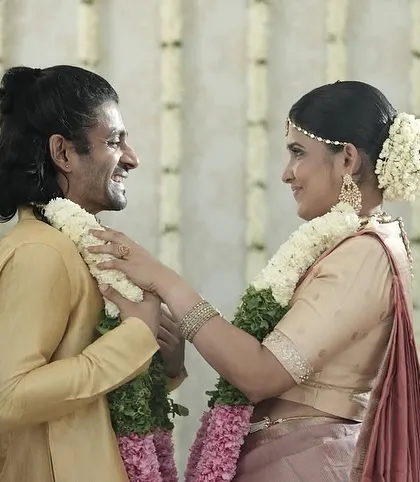 Capturing the joy of the ceremony is everything. This candid moment shows the bride and groom during their garland exchange. Her makeup is designed to be long lasting and picture perfect, with a natural radiance that doesn't overwhelm, allowing her happiness to be the focus.