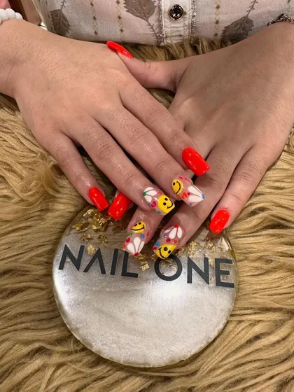 This view shows how the playful art nails are balanced by the solid, glossy red nails, creating a look that is both fun and bold.