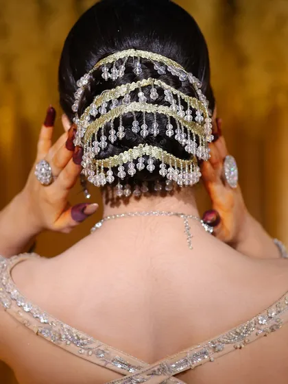 A bridal look is incomplete without the perfect hairstyle. This is a detailed view of an intricate bridal bun, woven with delicate crystal accessories. I design these styles to be secure, comfortable, and to beautifully complement the bride's outfit and jewelry from every angle.