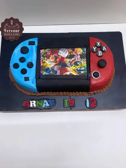 A Nintendo Switch cake made for a 12th birthday. This chocolate truffle cake is shaped and decorated to look exactly like the popular gaming console, with a Mario game on the screen.