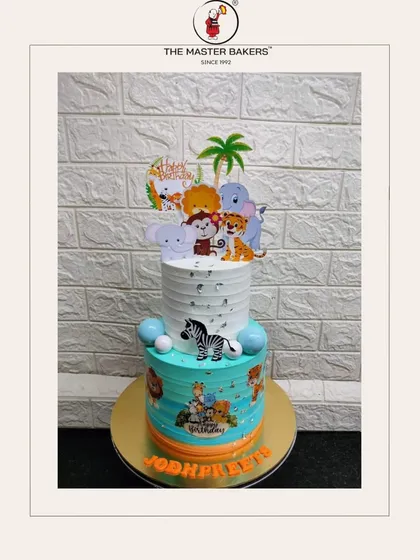 A wild jungle adventure for Jodhpreet's birthday. This two-tiered cake is decorated with friendly fondant animals, a zebra, and cute cartoon toppers, perfect for a safari-themed party.