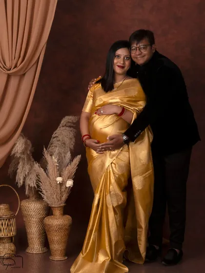 A full-length portrait of the couple, showcasing their elegant traditional attire and their happy, loving connection.