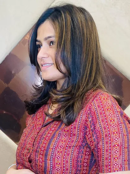 A happy client with a new layered haircut and subtle highlights. The color adds depth to the layers and frames her face beautifully.