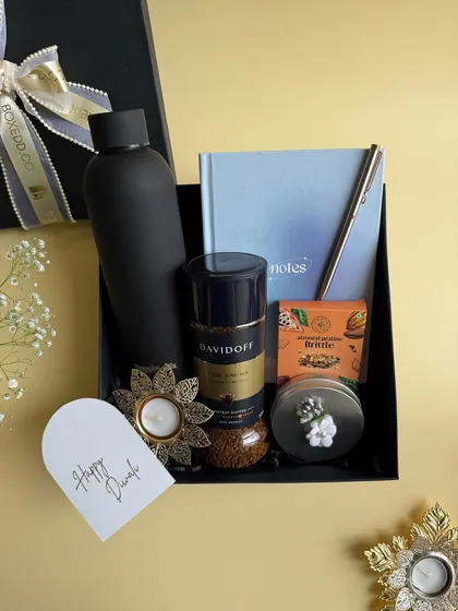 Another angle of our sophisticated black Diwali hamper. It showcases a curated selection of items including premium coffee, a notebook, and a matte black bottle, perfect for a modern corporate gift.