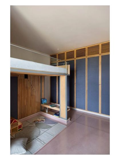 A playful and functional children's room with a bunk bed, integrated storage, and a durable pink terrazzo floor.