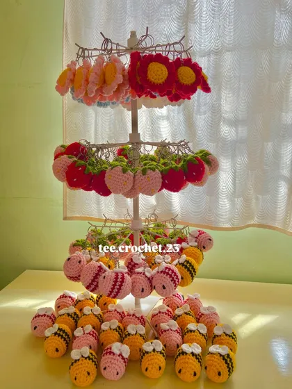 A full view of my keychain display stand, featuring handmade flower, strawberry, and bee designs. This is a great way to see the variety I can provide for your business.