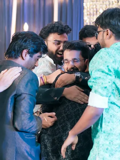 A big group hug for the groom from all his friends! A candid shot full of energy and friendship.