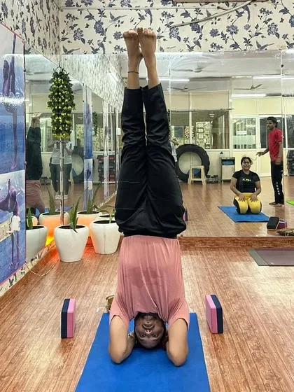 A student holding a perfect headstand (Sirsasana) in the middle of the class. Inversions are a key part of our practice, helping to improve circulation and focus.