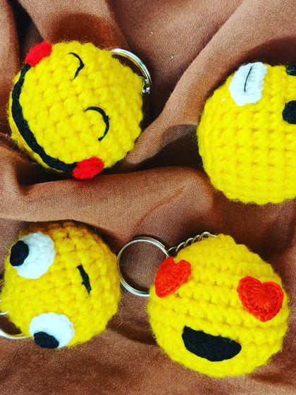 A close-up of four different emoji keychains, each capturing a different feeling. Which one matches your vibe today?