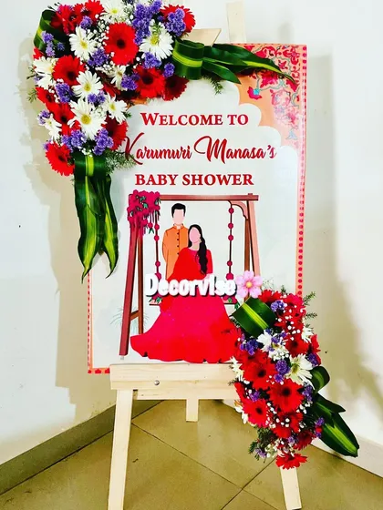 Another example of our custom welcome signs, this one for Manasa's baby shower. We adorned the easel and board with vibrant bouquets of red, white, and purple flowers to match the traditional theme of the event.