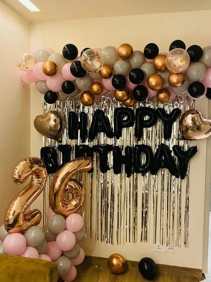 Another angle of the chic 26th birthday decor, showing the large rose gold number balloons and confetti-filled accent balloons.