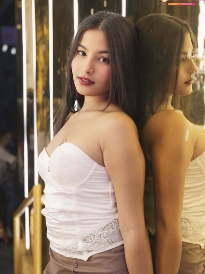 A guest posing against a reflective, lit-up wall.