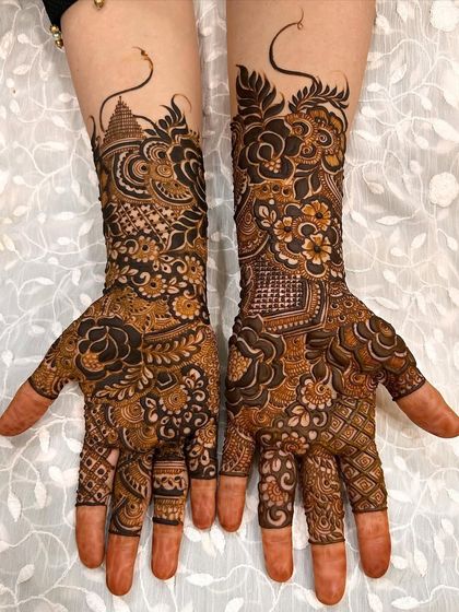 This design features a mix of architectural elements like a temple dome alongside floral patterns, creating a unique and symbolic bridal mehendi.