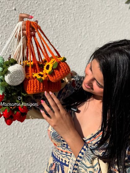 Holding a bunch of our hanging car charms, including the sunflower and strawberry pot designs. They are a cheerful companion for every drive.