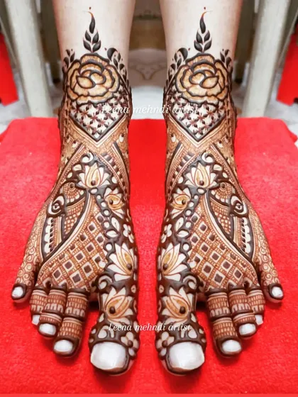 Bridal foot mehndi requires both precision and artistry. This design combines classic rose motifs with geometric patterns and delicate peacock figures, ensuring the bride looks stunning from head to toe.