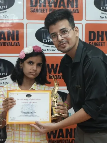 A teacher presents an award to a student.