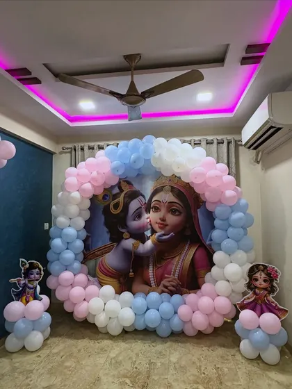I can blend traditional themes with modern decor styles. For this baby shower, I used a beautiful Krishna and Yashoda backdrop, framed with a soft pink and blue balloon arch to welcome the new baby.