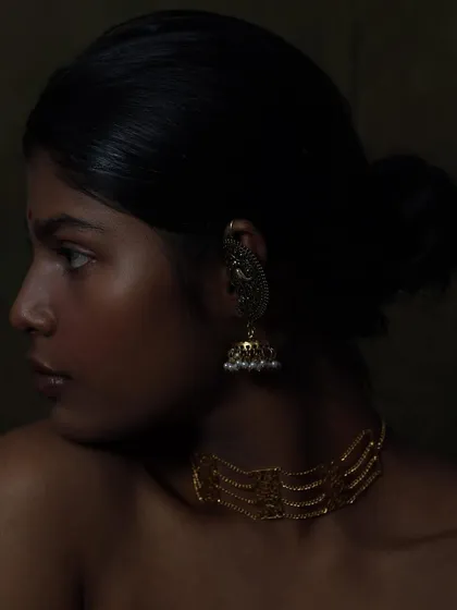A fine art approach to jewellery photography. I used chiaroscuro lighting to sculpt the model's features and make the gold jewellery glow against her skin.