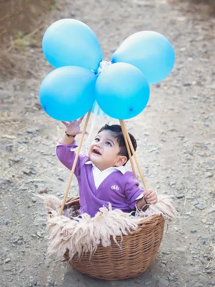 Up, up, and away. Using props like these blue balloons, we created a whimsical hot air balloon concept for this outdoor shoot.