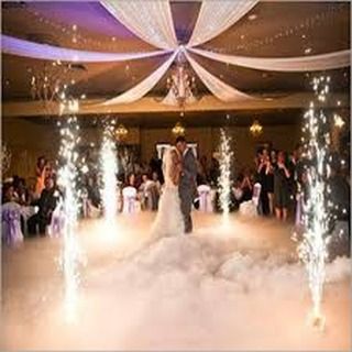 This image shows a couple having their first dance surrounded by low-lying smoke and cold fire fountains. This combination creates a truly romantic and dramatic effect.