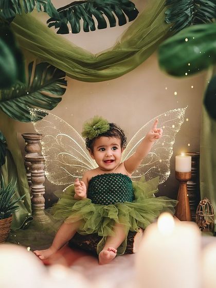 This tiny tinkerbell, with her green tutu and glowing wings, is pointing out the magic in her enchanted forest.