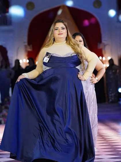 A beautiful plus-size model in a royal blue satin gown. The simplicity of the design is elevated by the luxurious fabric and perfect fit.