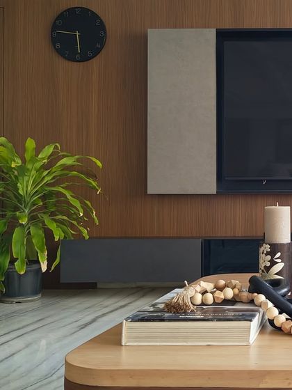 A close-up of a sleek, modern living room. The combination of a wood-paneled wall, a floating console, and a touch of greenery creates a clean and contemporary style.