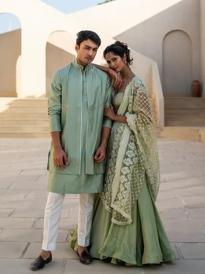 Here’s how you nail a coordinated daytime look. We styled this couple in complementary mint green outfits, a lightweight lehenga for her and a smart layered kurta for him. It's fresh, elegant, and perfect for a mehendi or outdoor event.