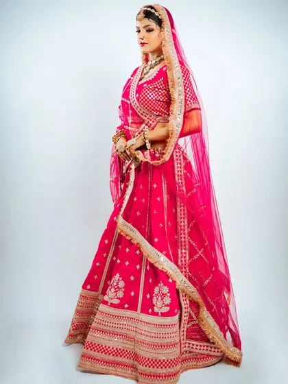 A full side view of the pink Marwadi bridal lehenga, showing the beautiful drape of the dupatta and the intricate gota patti work.