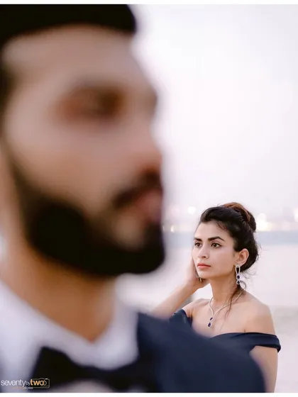 A creative portrait with a focus on her, her gaze thoughtful and serene. He is a soft presence in the foreground, a beautiful composition that tells a story of quiet admiration.