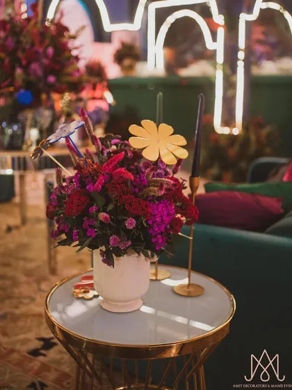 A vibrant floral centerpiece with a playful paper flower cutout, adding a touch of modern artistry to the table.
