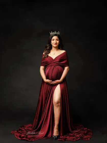A powerful portrait of a queen on her throne. The rich red gown, the crown, and the dark background create a look of pure regality.