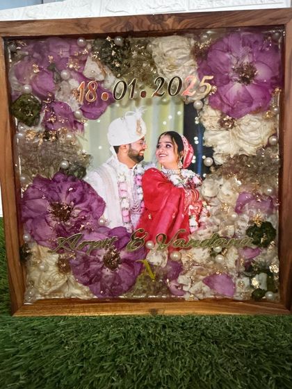 An angled shot of a varmala frame, highlighting the depth and dimension created by layering the flowers in clear resin. The details are sealed perfectly under a glossy finish.