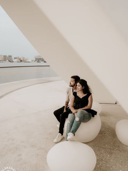 A happy, relaxed moment for the couple sitting on modern, orb-like seats.