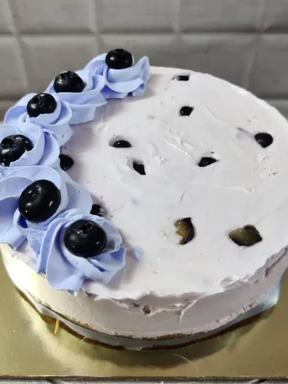 This is my blueberry cheesecake, a creamy and delicious dessert. It's topped with fresh blueberries and swirls of light purple, blueberry-infused cream for a fruity and refreshing flavor.