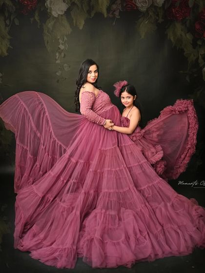 A magical mother-daughter portrait. The matching mauve gowns and the flowing fabric create a stunning, fairytale-like image that celebrates their special bond.
