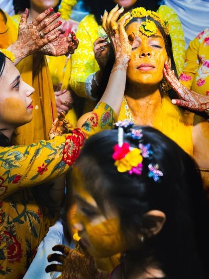 A close-up of the Haldi ceremony, a Hindu pre-wedding ritual where turmeric paste is applied to the bride for good luck.