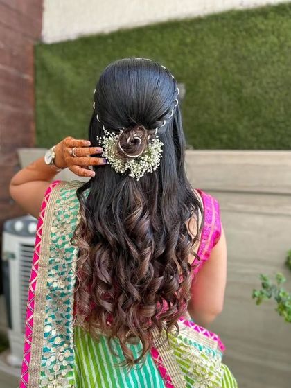 A detailed shot of a beautiful floral and rose-bun hairstyle, perfect for a Mayera or Haldi event.