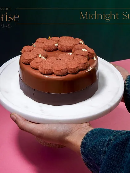 Holding the Midnight Sun, ready to be served. This cake is one of my signature creations, a testament to the timeless combination of chocolate and caramel.