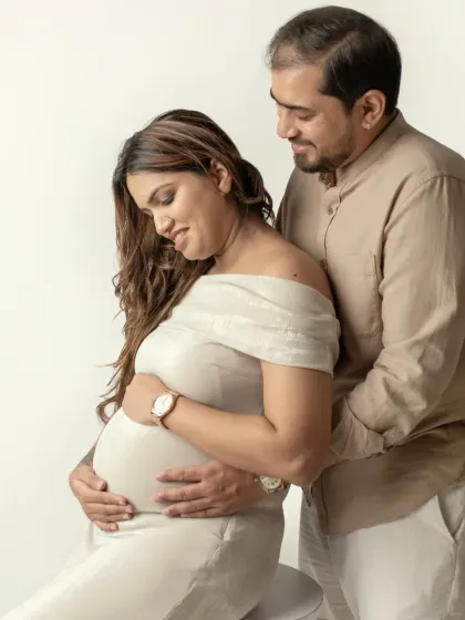 I love capturing these gentle interactions. Here, the father to be looks on with adoration as his partner holds her belly, a quiet moment of connection in our studio.